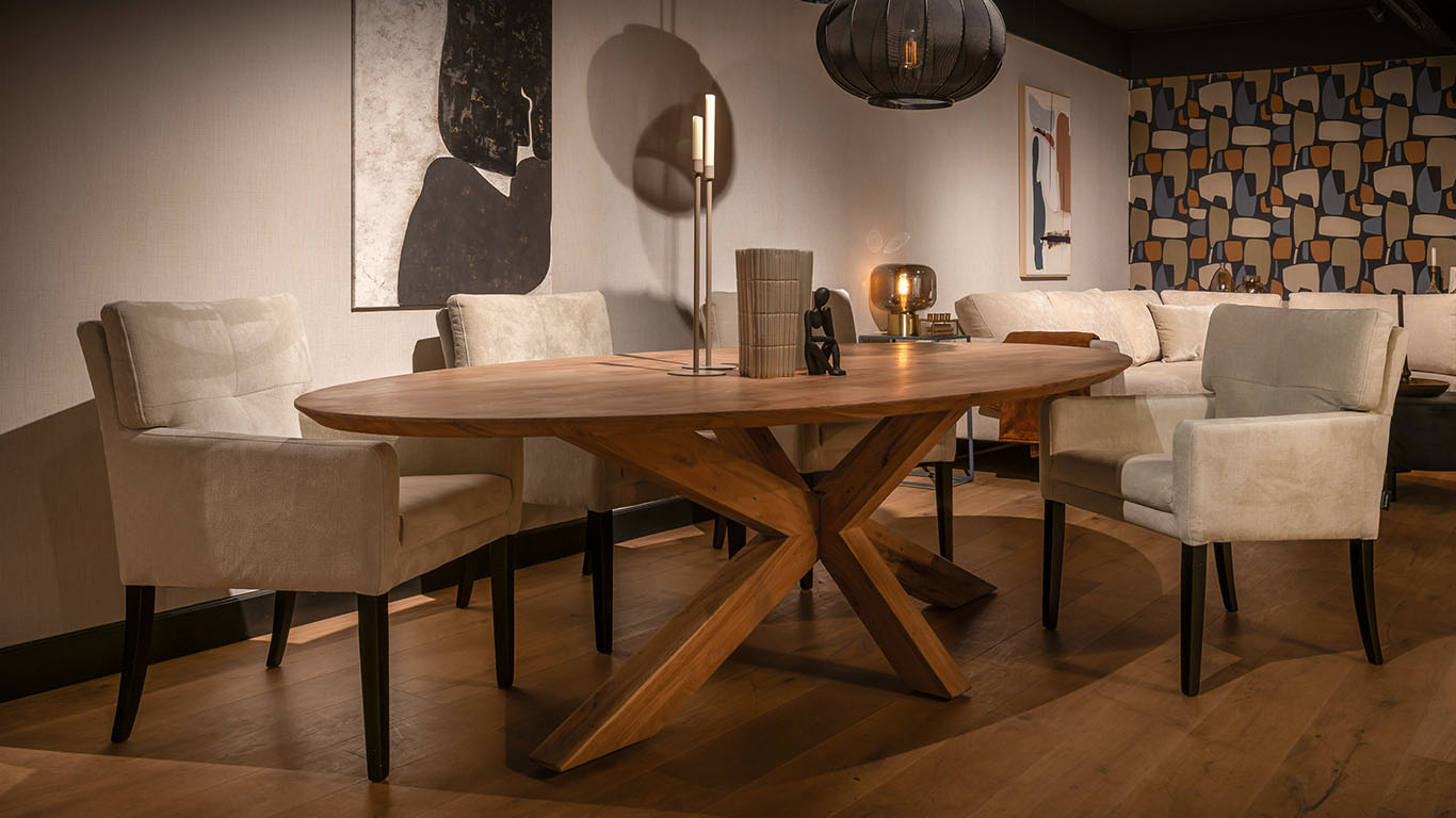 Charmante Bruuts Espen ovale eettafel met robuuste houten spider-leg onderstel in Woodbury finish, gecombineerd met de UrbanSofa Quinten eetkamerfauteuils in de zachte Monti stof in de kleur beige.